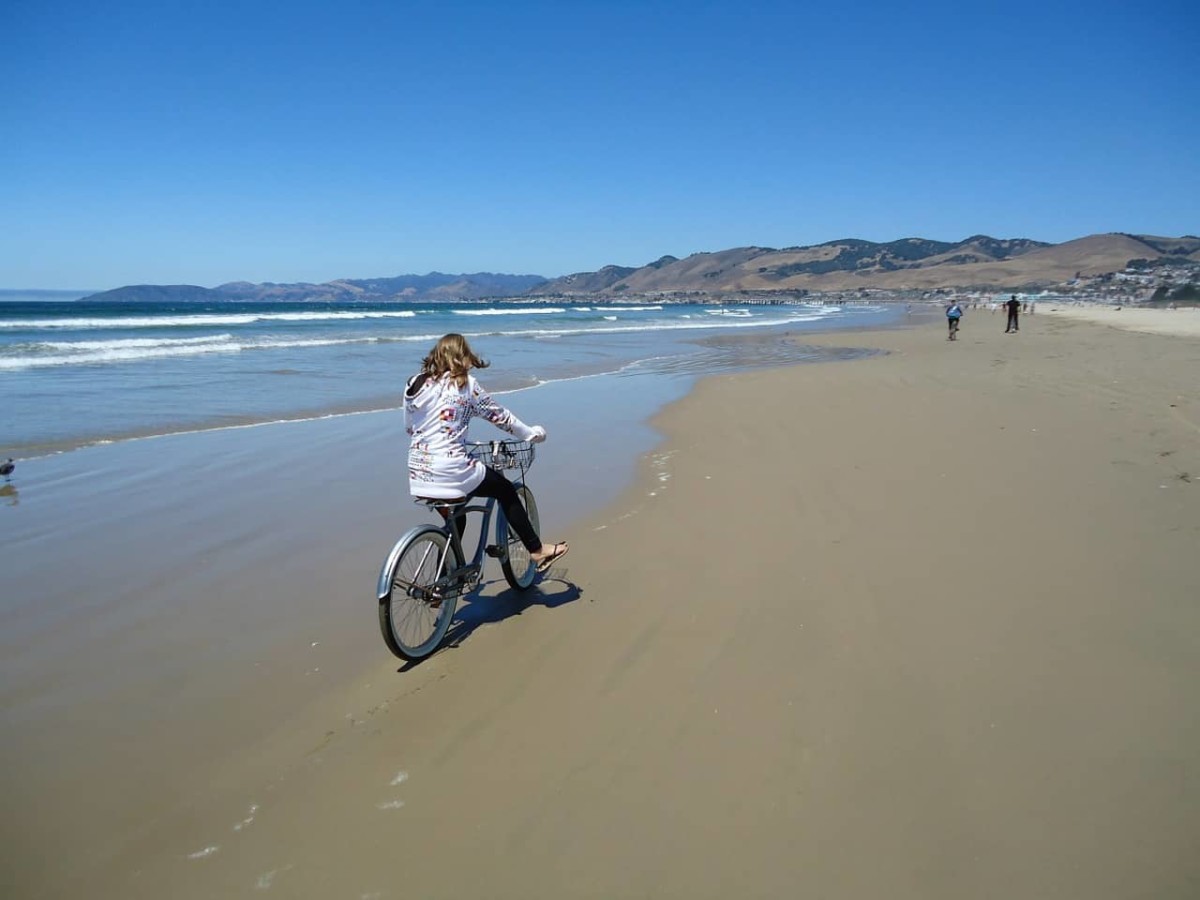 woman riding a bike on Pismo Beach