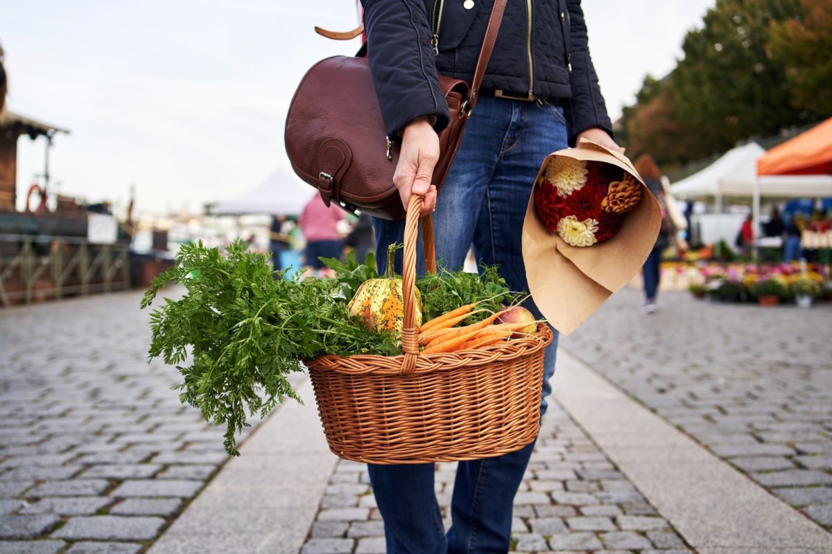 lady holding basket of fresh veggies
